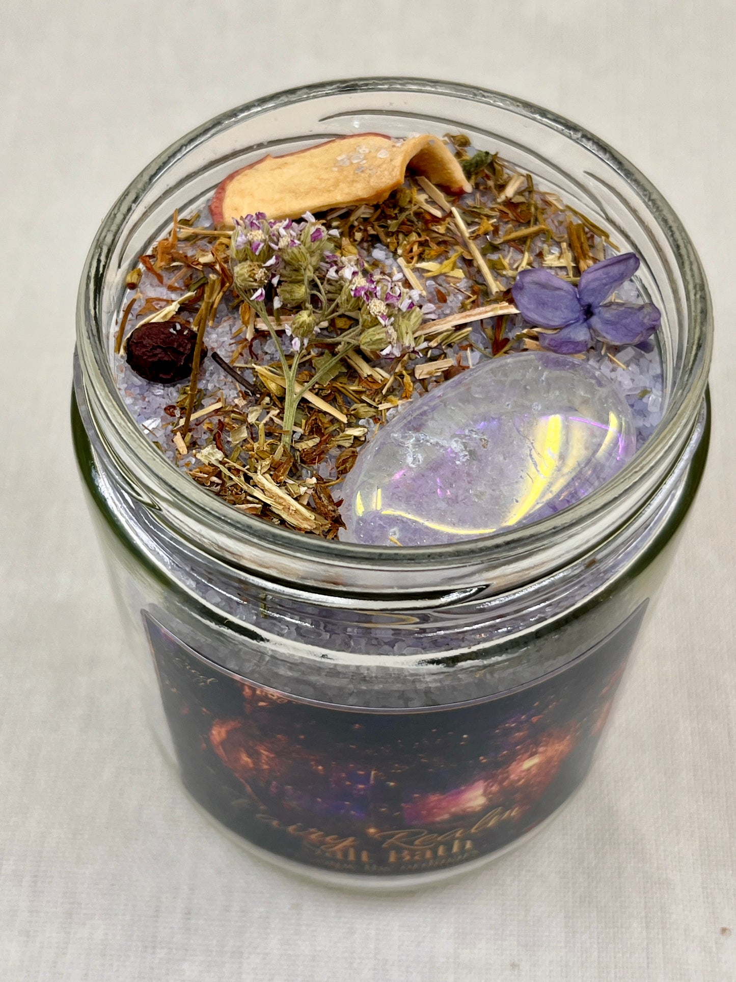 Glass jar with dried herbs and a butterfly on a white background