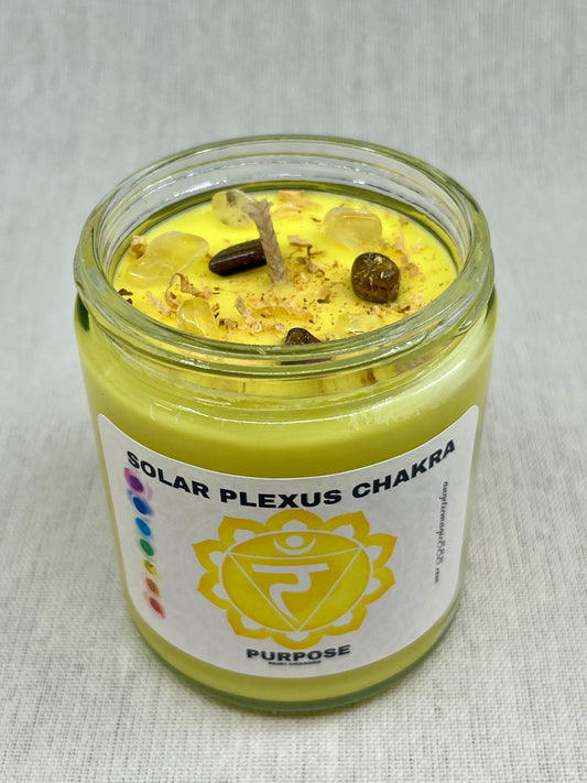 Candle in a glass jar labeled 'Solar Plexus Chakra' on a light background