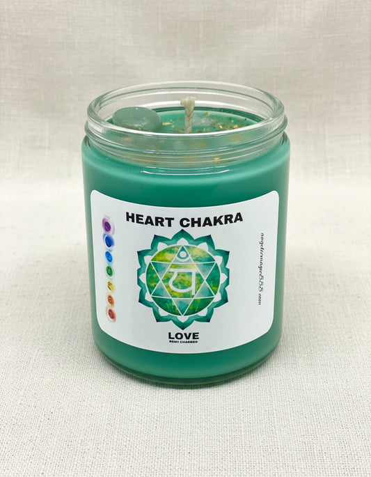 Green candle in a glass jar with a label indicating 'Heart Chakra' on a light background
