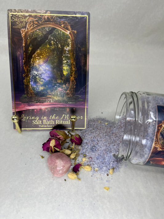 Decorative card with gold border and purple text, jar of purple powder, and dried flowers on a light gray background