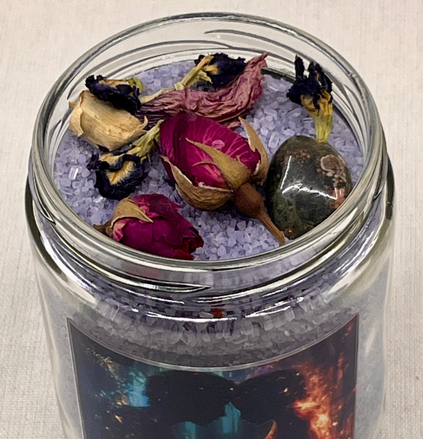 Jar of salt bath with dried flowers and stones on a neutral background