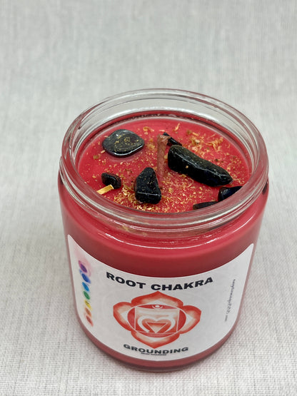 Red candle in a glass jar labeled 'Root Chakra' on a white background