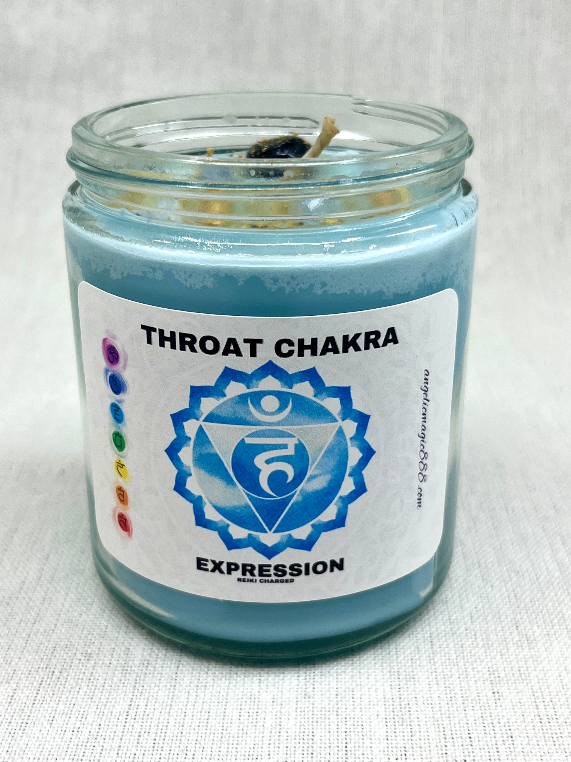 Candle in a glass jar labeled 'Throat Chakra Expression' on a white background