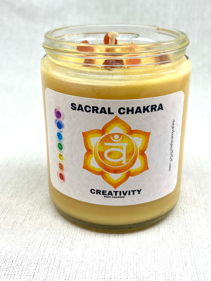 Candle in a glass jar labeled 'Sacral Chakra' with a white background