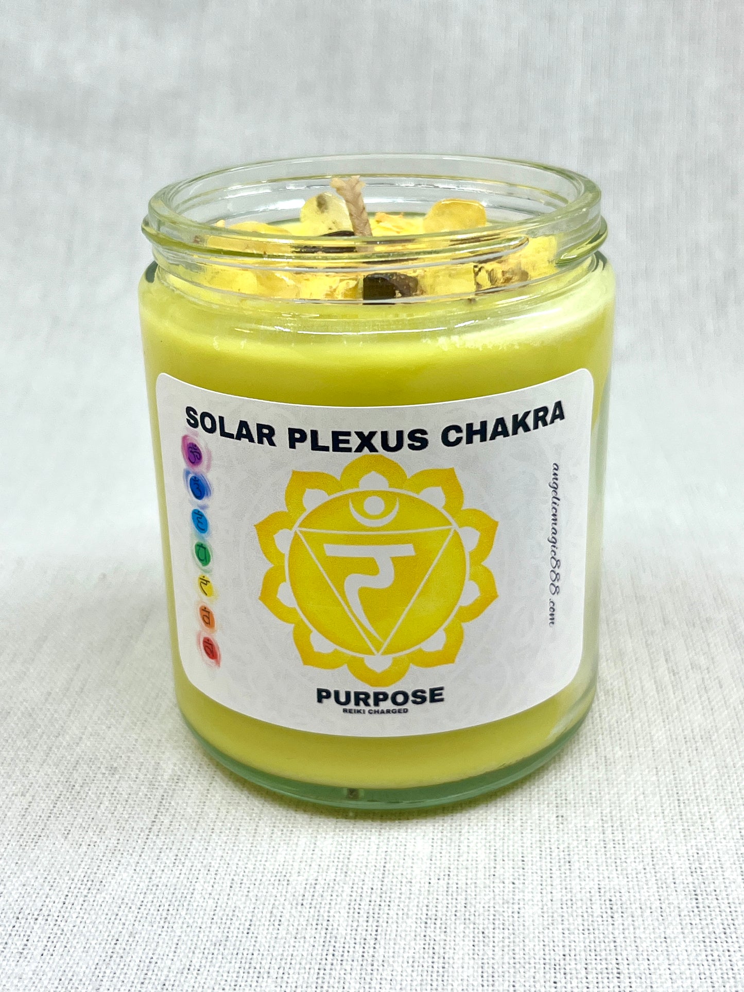 Candle in a glass jar labeled 'Solar Plexus Chakra' with a white background