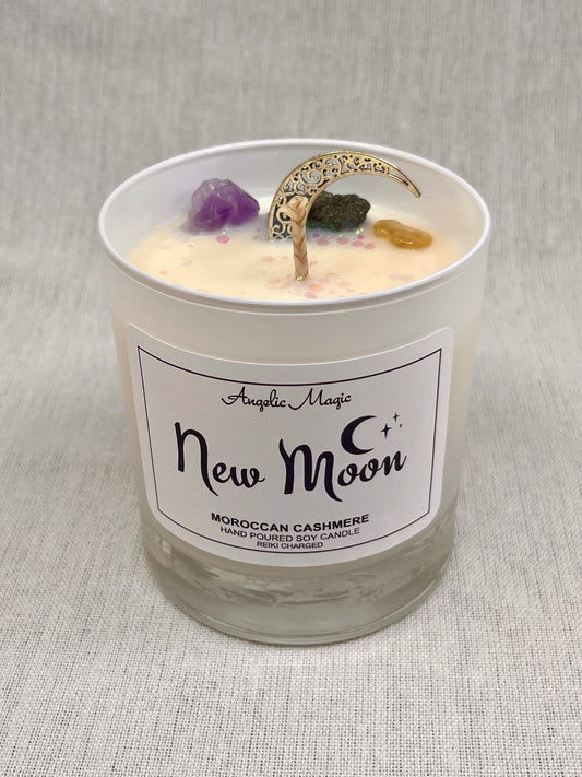 Candle in a glass jar labeled 'New Moon' with decorative elements on a textured gray background