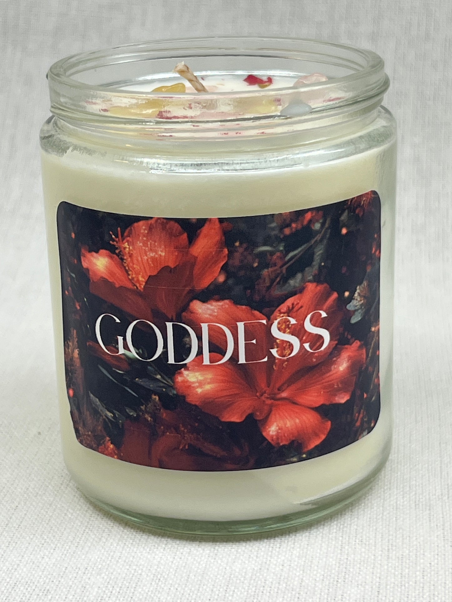 Candle jar with floral label and 'Goddess' text on a white background