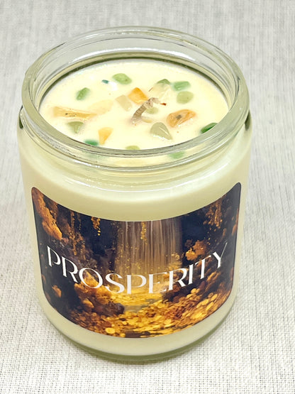 Candle in a glass jar with 'Prosperity' label on a textured surface