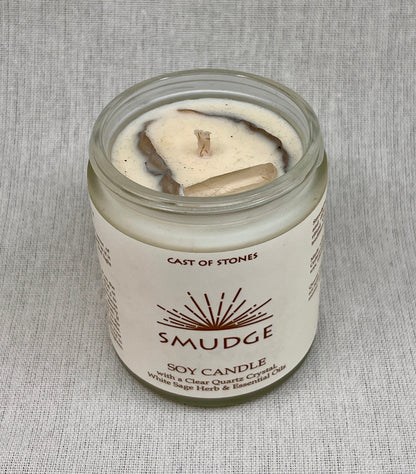 Smudge soy candle in a glass jar with a label on a gray background