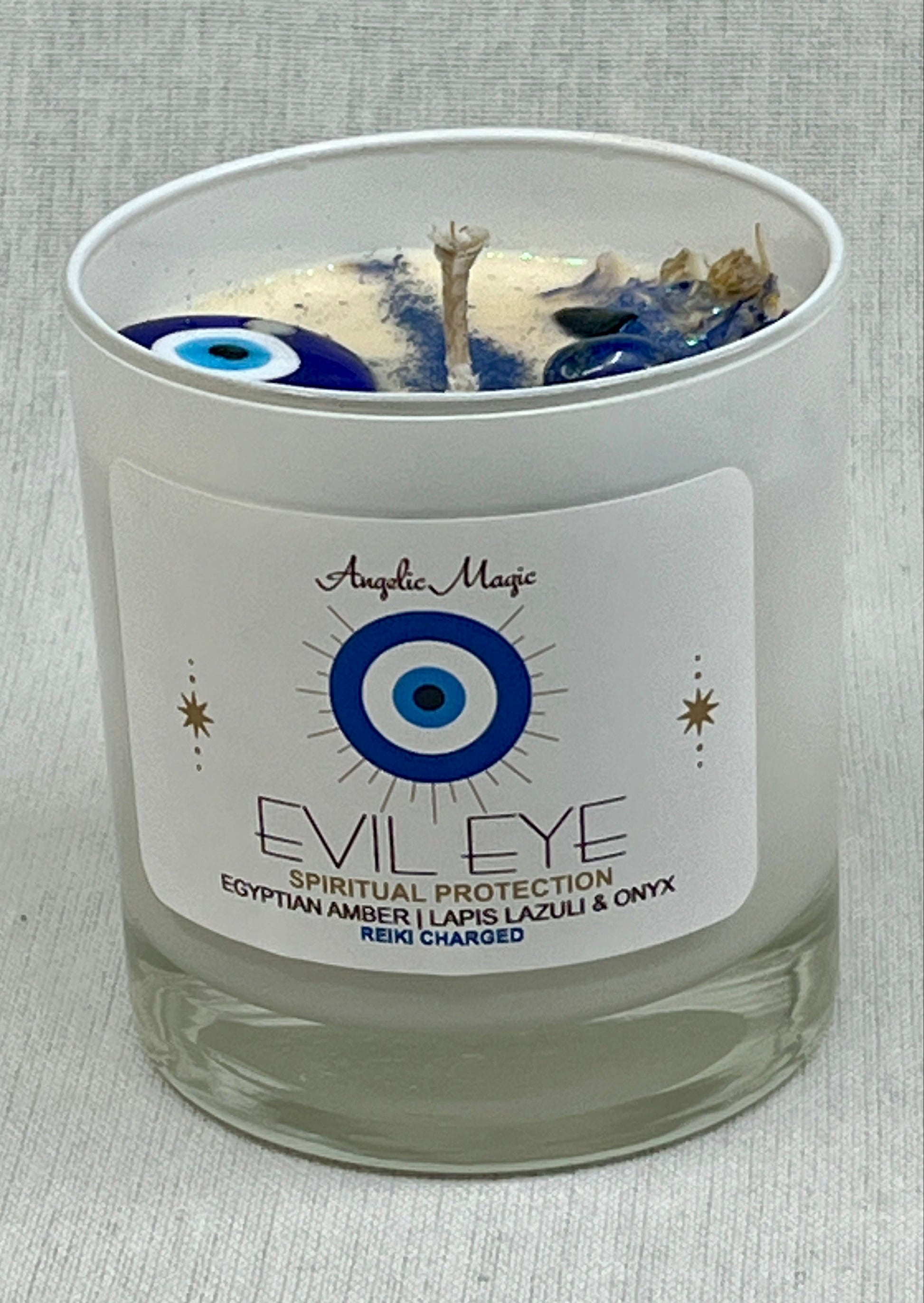 Candle with 'Evil Eye' label and decorative elements on a gray background