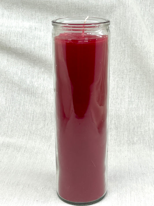 Red candle in a clear glass jar on a white fabric background
