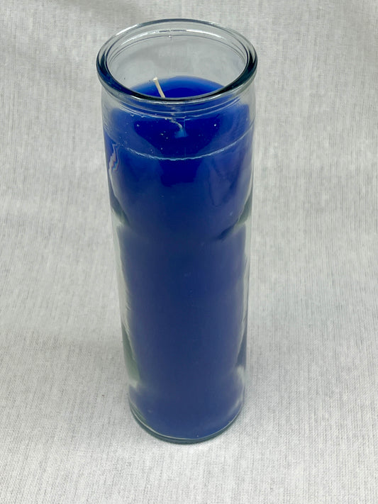Blue candle in a clear glass holder on a light gray background