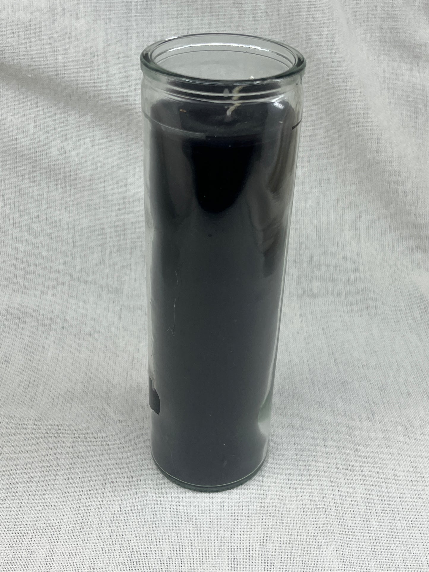 Black cylindrical candle on a gray background