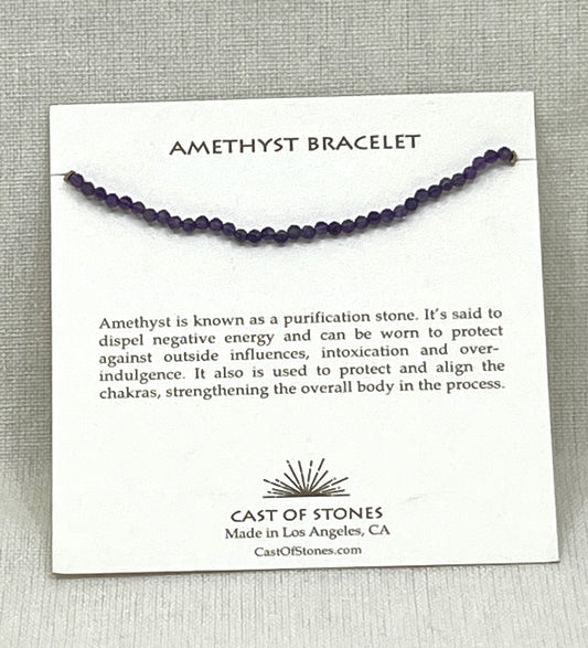 Amethyst bracelet on a card with product description and brand information, on a gray background
