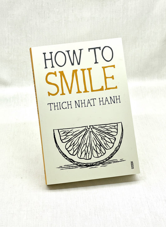 Book titled 'How to Smile' by Thich Nhat Hanh on a light background