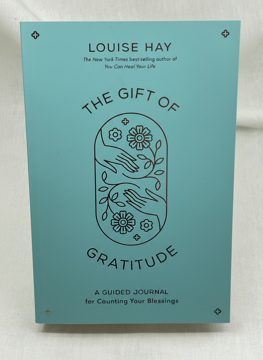 Book titled 'The Gift of Gratitude' by Louise Hay on a light background