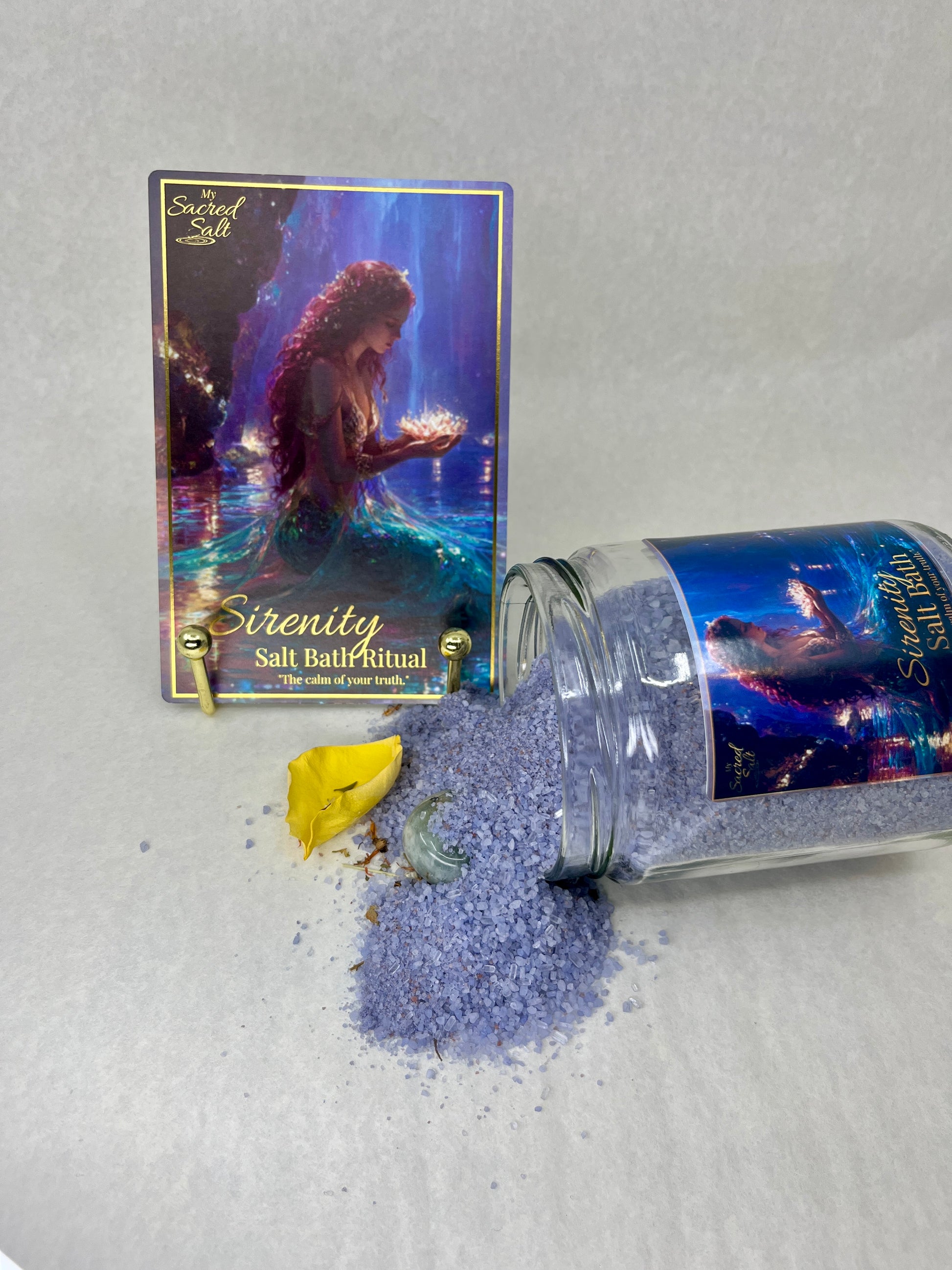 Serenity salt bath ritual packaging with spilled salt on a light gray background