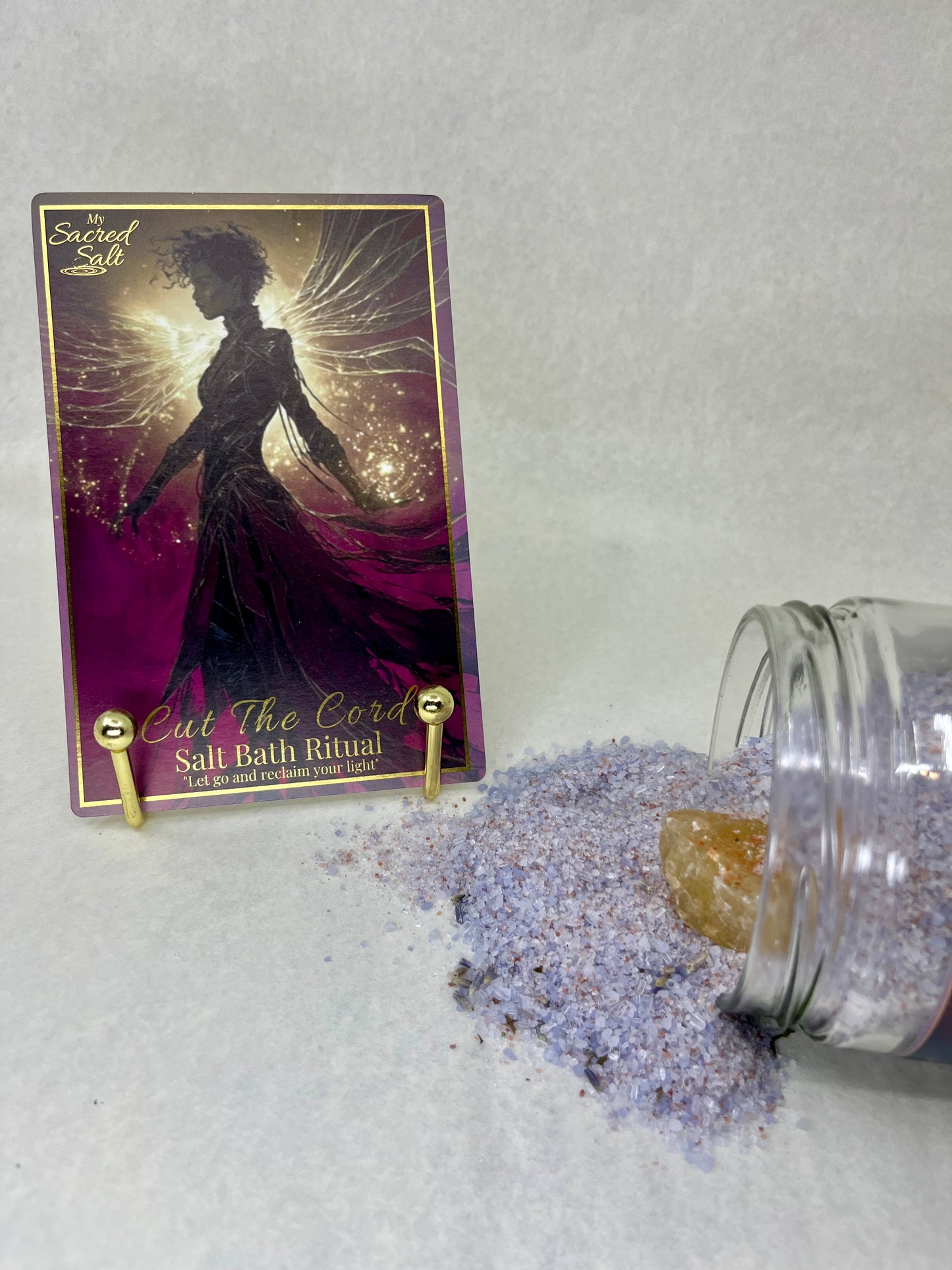 Salt bath ritual product with a purple card featuring a silhouette of a woman on a textured gray background.