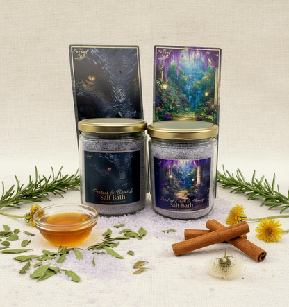 Two jars of salt bath products from the Protected & Abundant Salt Bath Collection with botanicals and their matching ritual cards on a white background