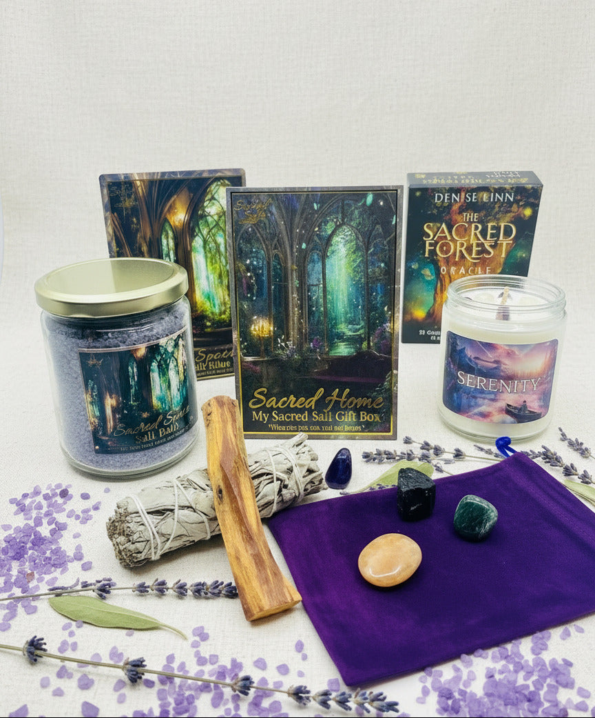 Set of items from the My Sacred Salt Sacred Home Gift Box including candles, boxes, Sacred Space Salt Bath with matching ritual card, sage and palo santo and crystals on a white surface with a purple crystal pouch. Purple salts and dried botanicals surround the display