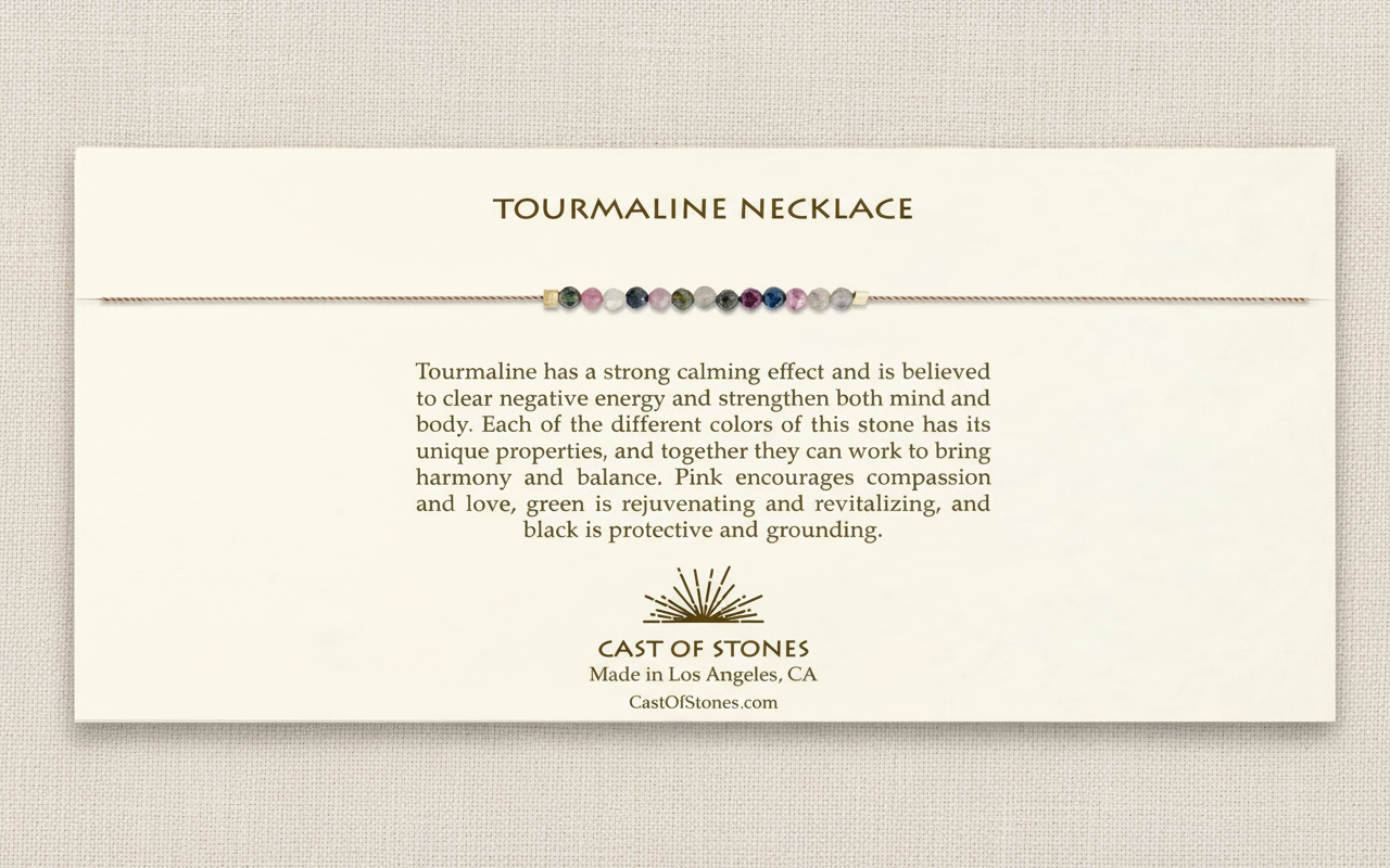 A Tourmaline necklace with a description card about its properties on a textured beige background.