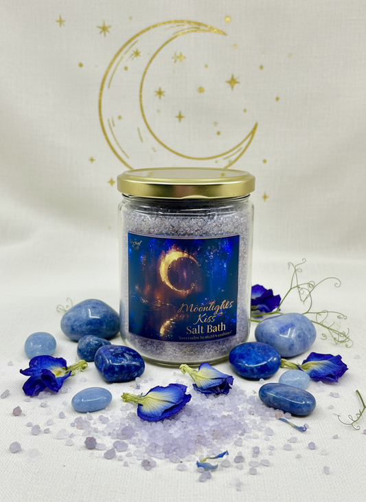 Jar of 'Moonlight Kiss' salt bath with blue flowers and decorative elements on a white background.