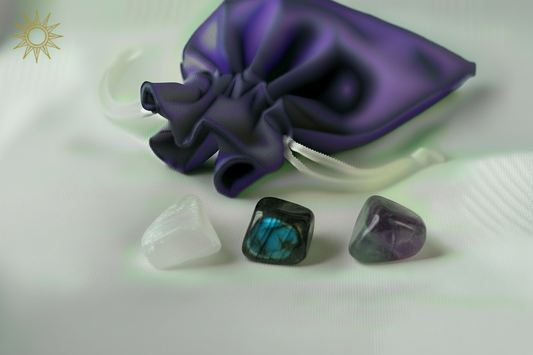 Purple satin bag with three crystal stones on a white background