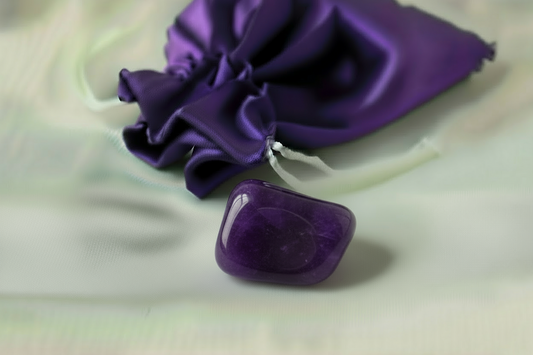 Purple stone and small pouch on a light background