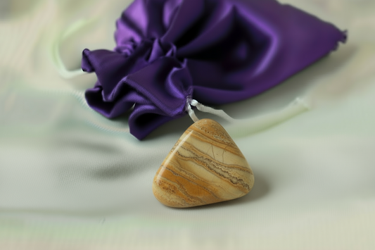 Triangular stone with a purple drawstring bag in the background