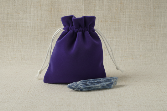 Purple drawstring bag with a crystal on a beige fabric background
