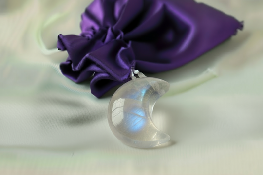 Clear moon-shaped stone with a purple bag in background