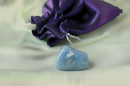 Blue stone on a light background with a purple fabric bag in the background
