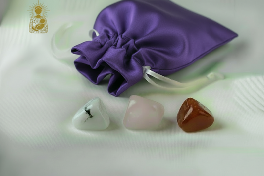 Purple satin drawstring bag with three stones on a light background