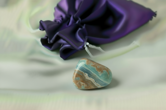 Decorative stone with a string on a purple fabric background